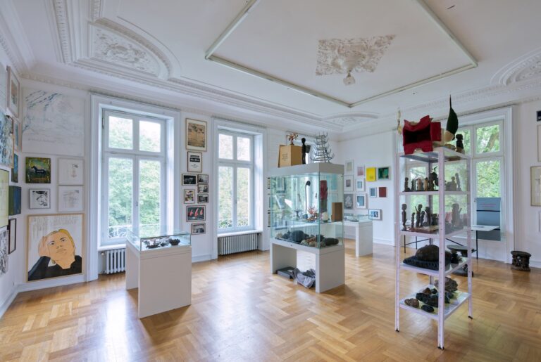 mit Werken von Bernd Ackfeld, Martin Assig, Joseph Beuys, Michael von Biel, Bittermann & Duka, Caroline Bittermann, Stefan Bohnenberger, Gerd Bonfert, Natascha Borowsky, Alexander Braun, Berlinde De Bruyckere, Peter Buggenhout, Franz Burkhardt, Oliver Czernetta, Mark Dion, Reinhard Doubrawa, Peter Duka, Marcel Dzama, Marcel van Eeden, Jochen Flinzer, Günther Förg, Klaus Gaida, Pierre Granoux, Tobias Hantmann, Antonius Höckelmann, Gustav Kluge, Mischa Kuball, Jochen Lempert, Bärbel Messmann, Ulrich Moskopp, Marcus Neufanger, Chris Newman, Olaf Nicolai, Jürgen Paas, Franziska Reinbothe, Thomas Ruff, Roland Schappert, Nora Schattauer, Stefan Schmitz, Adrian Schoormans, Norbert Schwontkowski, Christian Sery (Sery C.), Thomas Struth, Gert & Uwe Tobias, Rosemarie Trockel, Günter Tuzina, Ecki Vespa, Johannes Wohnseifer, 4000, u.a. sowie einer kleinen Auswahl an Mineralien, Fossilien, Naturalia, Kuriositäten und Figuren und Kraftobjekten aus Afrika. Bücher zu den einzelnen Künstlern und Themen liegen zur Ansicht und Lektüre bereit.